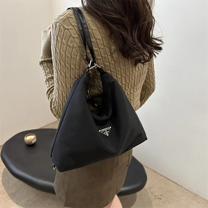 Minimalist black waterproof nylon shoulder bag with triangle logo and metal hardware
