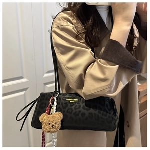 Detailed view of leopard print shoulder bag with a cute bear plush keychain