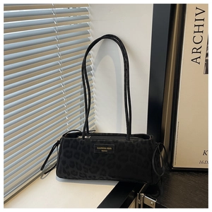 Detail of black leopard print tote bag with dual straps and metallic brand logo