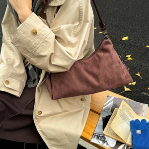 Vintage brown suede underarm shoulder bag styled with a beige autumn trench coat