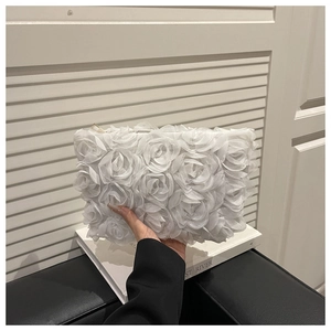 Detail of pure white three-dimensional fabric rose textures on a chic evening clutch bag