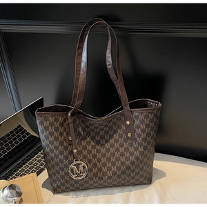 Détail du sac cabas vintage marron avec monogramme et pendentif en métal doré en forme de M