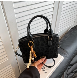 Détail du sac léopard en texture daim avec pendentif décoratif en perles de bois