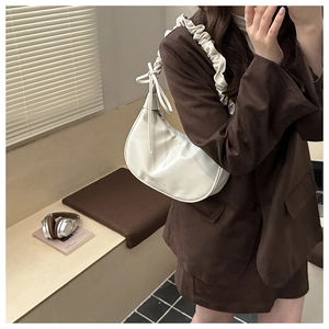 Vue détaillée du sac hobo blanc avec bandoulière plissée à nœud et logo de marque