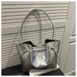 Detail of silver metallic tote bag featuring vintage cracked faux leather and knot drawstring