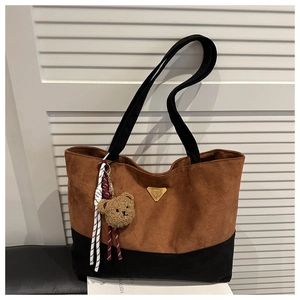 Detalle del bolso tote de ante con colores en contraste y un lindo colgante de osito