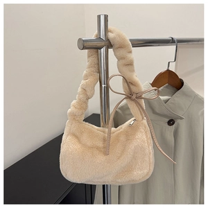 Detail of creamy white plush shoulder bag with elegant pleated handle and side ribbon bow