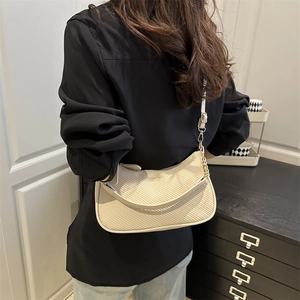 Minimalist beige woven underarm bag with golden chain and elegant crescent shape