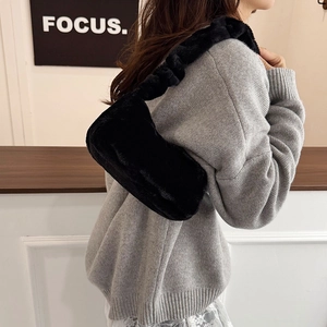 Fashionable black faux fur shoulder bag with ruched strap for a stylish winter look
