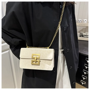 Detail view of cream leopard-print chain bag with golden square clasp on black trench coat