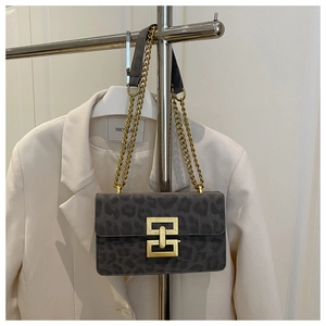Detailed close-up of dark leopard print crossbody bag with gold chain and metal lock