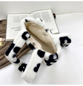 Detail view of plush cow print tote bag showing soft faux fur texture and magnetic closure