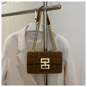 Detail of vintage leopard print crossbody bag with gold geometric clasp and chain strap