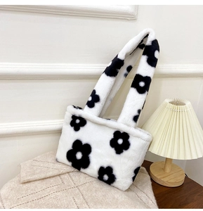 Close-up of soft white plush tote bag featuring black floral patterns and fuzzy texture