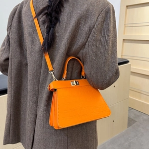 Schicke orange Handtasche mit Krokodilprägung, goldenem Drehverschluss und Schulterriemen