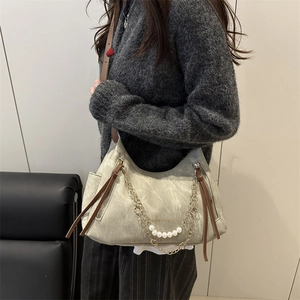Sac hobo en daim gris avec chaîne de perles, glands en cuir et bandoulière brune