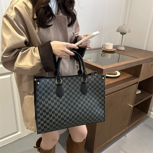 Large retro monogram tote bag with black leather handles for stylish daily commuting