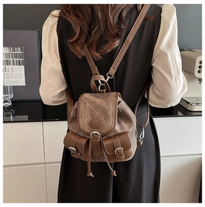 Détail du mini sac à dos en toile vintage avec finitions en cuir brun et poches multiples