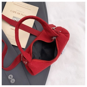 Détail du sac à bandoulière en velours côtelé rouge avec texture à grosses côtes