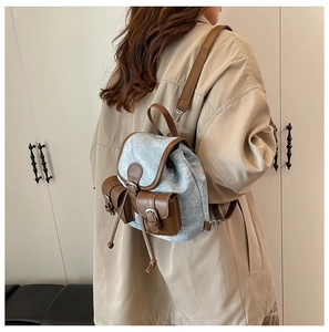Détails du mini sac à dos en denim gris avec garnitures en cuir marron et deux poches