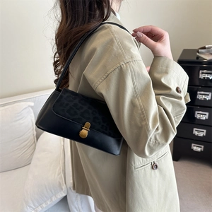 Retro black faux leather shoulder bag with leopard print flap and gold clasp on model