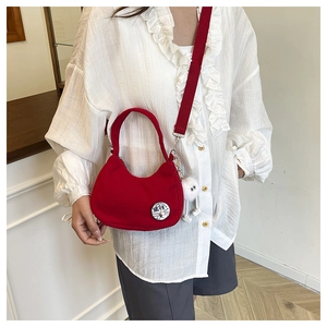 Détail du sac hobo en velours rouge avec broderie chinoise et breloque en peluche blanche