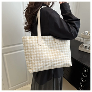 Detail of houndstooth woven tote bag texture with reinforced handle stitching