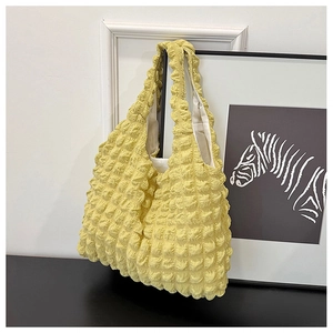 Close-up of bright yellow popcorn texture tote bag with soft pleated handles