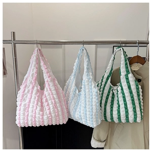 Close-up of textured popcorn fabric tote bags in pink, blue, and green stripes