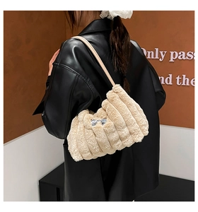 Détail du sac bandoulière en peluche beige avec nœud en métal argenté et sangle