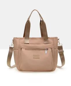 Front view of beige nylon tote bag with multiple pockets and adjustable shoulder strap