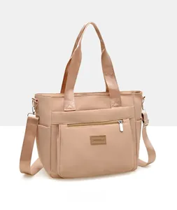Side view of beige nylon tote bag with multiple pockets and adjustable shoulder strap