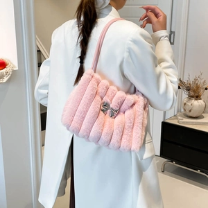 Elegante borsa a spalla in peluche rosa con fiocco argento indossata da modella