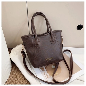 Close-up of vintage dark brown tote bag with gold lettering and natural leather texture