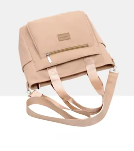 Detail view of apricot nylon tote bag with adjustable strap and silver metal hardware