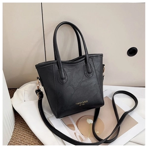 Detail of black lychee grain leather tote bag with gold metal hooks and logo branding