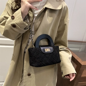 Classic black quilted crossbody bag with golden square lock and chain strap on model