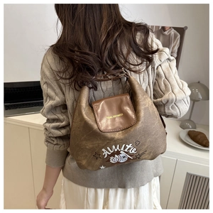 Detail of vintage brown textured shoulder bag with chic cartoon baseball print and lettering