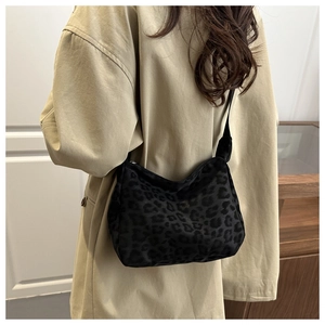 Close-up of black leopard print shoulder bag in soft fabric with zipper detail
