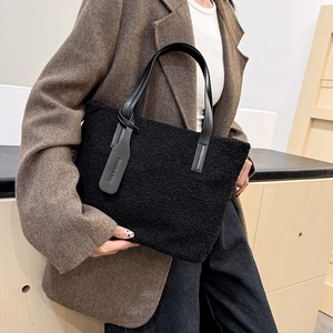 Minimalist black fleece bucket bag with leather handles and fashion tag for autumn