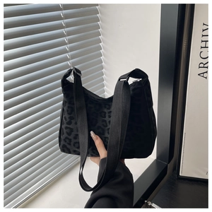 Detail of hobo shoulder bag featuring black leopard print and soft textured fabric