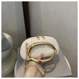 Dettaglio della pochette da sera in camoscio bianco con manico dorato e catena