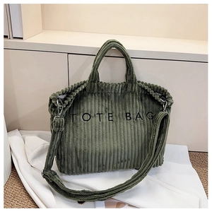 Detail of dark green corduroy tote bag showing the textured fabric and tote bag embroidery