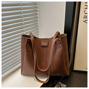 Detailed close-up of dark brown pebble leather tote bag with Fashoin magnetic buckle
