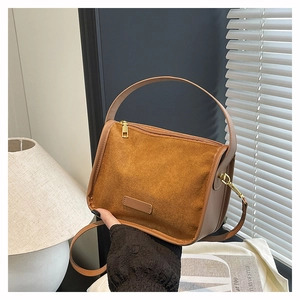 Detailed view of brown frosted leather tote with golden hardware in a cozy artistic setting