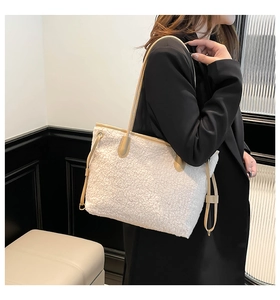 Detail of white faux shearling tote bag with tan leather handles worn by model