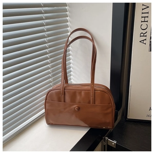 Detailed view of caramel faux leather pillow bag with stylish pocket and zipper close