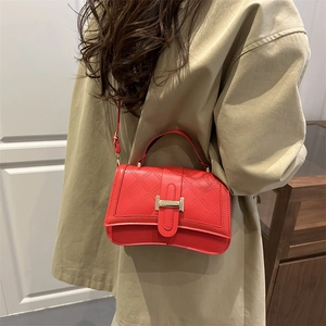 Rote Stepptasche mit goldener Schnalle, getragen über einem hellbeigen Trenchcoat