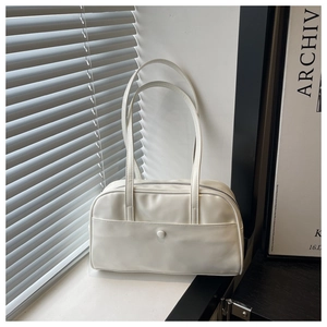 Close-up of minimalist cream white faux leather pillow bag with flap pocket and zipper detail