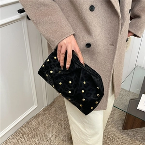 Pochette léopard en velours avec clous dorés portée avec un manteau en laine chic